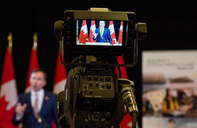 Minister of Finance Bill Morneau is seen through a television camera as he speaks at a press conference at the media lock-up, before tabling the budget in the House of Commons on Parliament Hill, in Ottawa on Wednesday, March 22, 2017. THE CANADIAN PRESS/Justin Tang