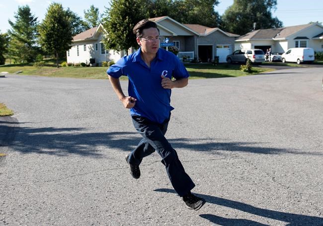Pierre Poilievre, Conservative candidate for Carleton, runs to the next house while campaigning door to door ahead of the 2019 federal election, in the Ottawa community of Greely, on Tuesday, Sept. 17, 2019. THE CANADIAN PRESS/Justin Tang