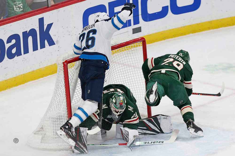(AP Photo/Stacy Bengs)
Winnipeg Jets' Blake Wheeler crashes into Minnesota Wild goalie Devan Dubnyk after driving the net in the first period Thursday, in St. Paul, Minn.