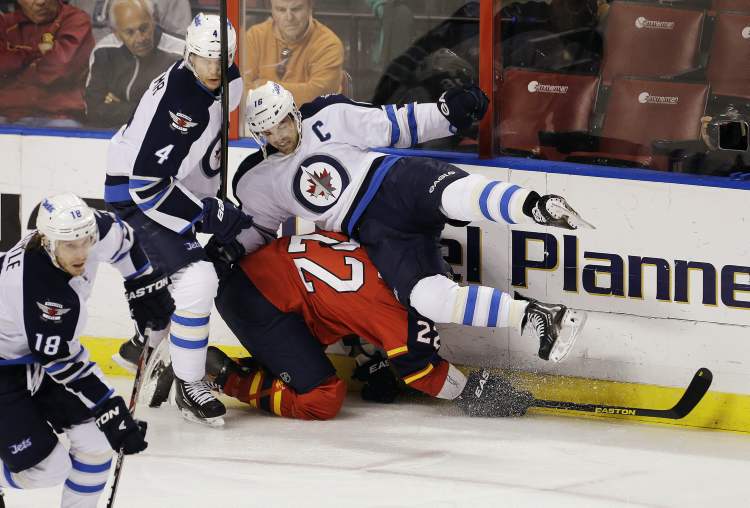 J Pat Carter / the associated press
Winnipeg Jets defenceman Paul Postma (4) and forward Andrew Ladd (16) block Florida Panthers' George Parros as Jets forward Bryan Little (18) steals the puck during the first period of an NHL game in Sunrise, Fla., Tuesday.