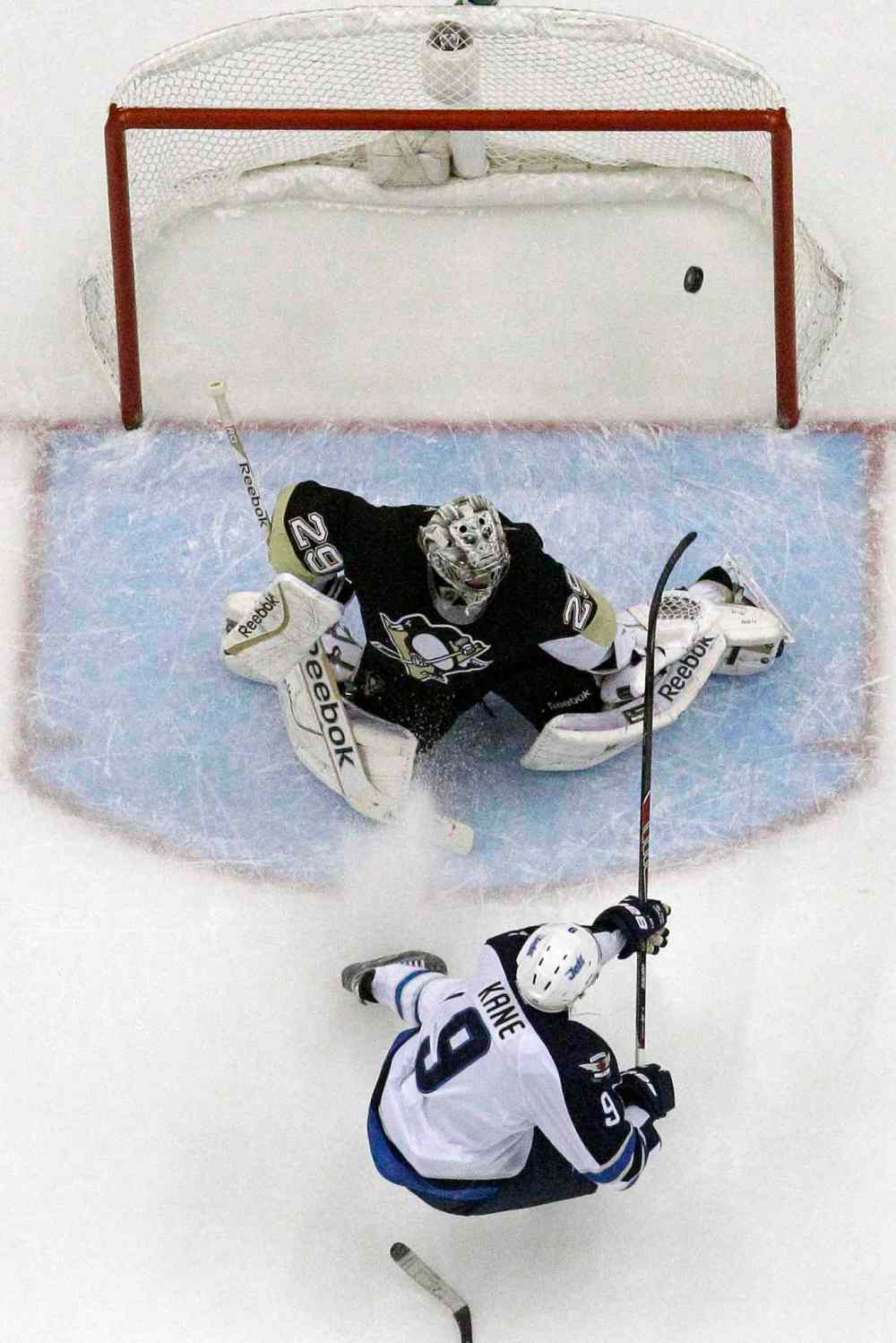 GENE J. PUSKAR / THE ASSOCIATED PRESS
Jets’ Evander Kane backhands a shot past Penguins goalie Marc-Andre Fleury in the second period for the first of his two goals Sunday in Pittsburgh. The Penguins won 6-5 in a score-fest.