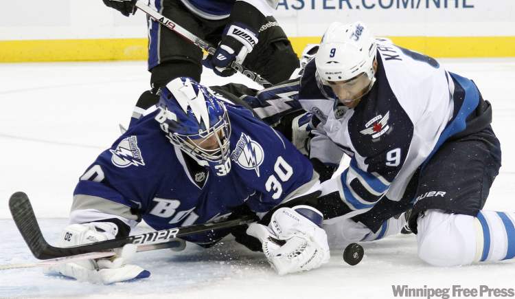 CP
Tampa Bay Lightning goalie Dwayne Roloson (30) battles with Winnipeg Jets left wing Evander Kane (9) for a loose puck during the first period of an NHL hockey game on Saturday, Oct. 29, 2011, in Tampa, Fla. (AP Photo/Chris O'Meara)