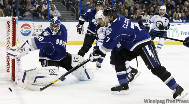 CP
Tampa Bay Lightning goalie Dwayne Roloson (30) knocks away a shot by Winnipeg Jets centre Kyle Wellwood, center, as Lightning defenceman Brett Clark (7) goes after the puck during the first period of an NHL hockey game on Saturday, Oct. 29, 2011, in Tampa, Fla. (AP Photo/Chris O'Meara)