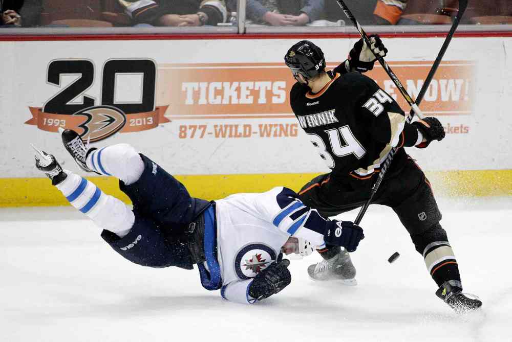 Jae C. Hong / The Associated Press
Winnipeg's Andrew Ladd takes a tumble to the ice while fighting for the puck with Anaheim's Daniel Winnik during the first period at the Honda Center Tuesday.