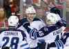 Larry MacDougal / The Canadian Press 
Winnipeg Jets' Paul Postma, centre, celebrates his game-winning goal against the Calgary Flames with Patrice Cormier, left, and Carl Klingberg on Friday to end the Jets' final game of the season.