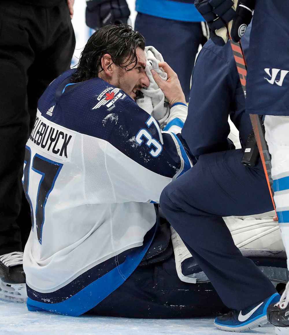 (AP Photo/Chris O'Meara)
Winnipeg Jets goaltender Connor Hellebuyck wipes his face after getting cut by a shot that hit him on the mask during the second period Tuesday.