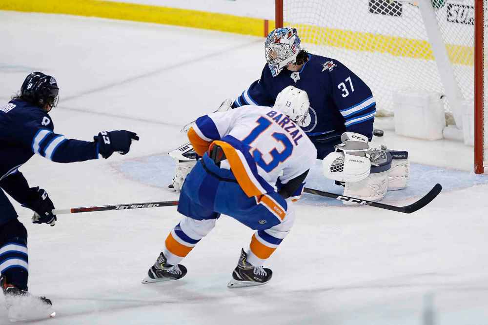 THE CANADIAN PRESS/John Woods
Winnipeg Jets goaltender Connor Hellebuyck can't stop a shot by New York Islanders' Mathew Barzal during the first period.