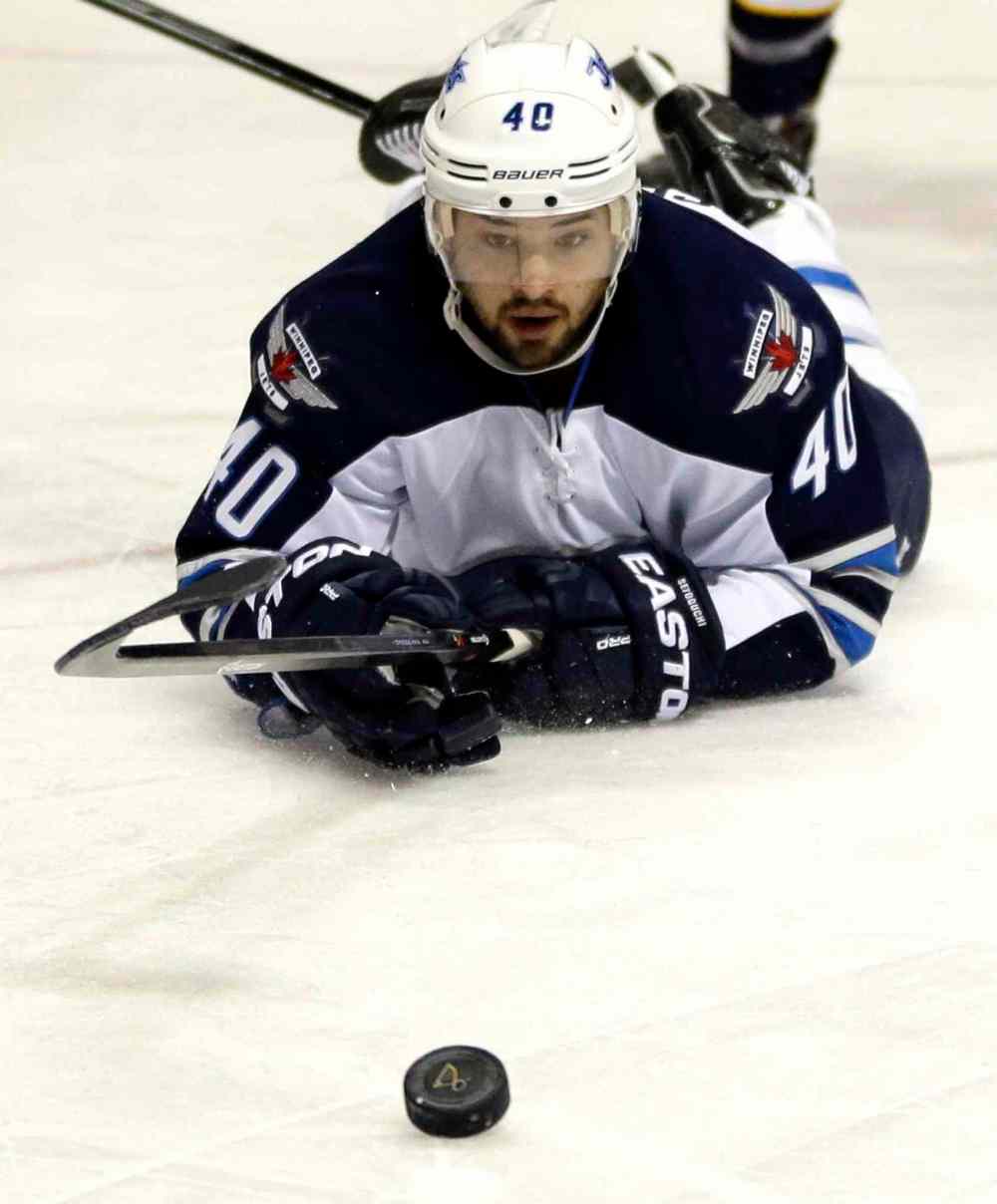 Jeff Roberson / The Associated Press
Winnipeg Jets' Devin Setoguchi keeps his eye on the puck after falling to the ice Saturday.