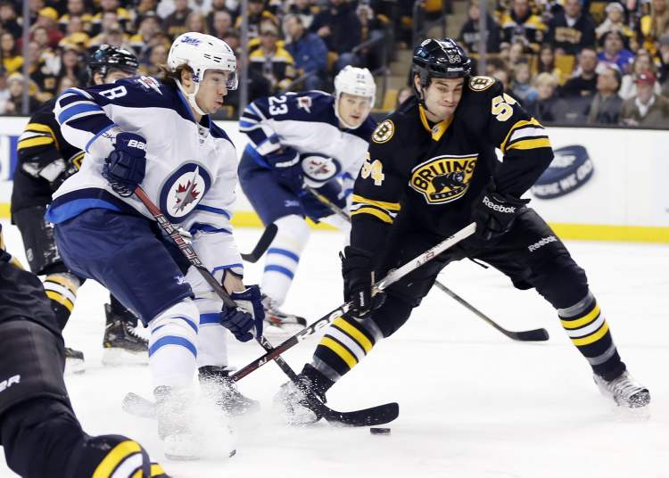 Michael Dwyer/ The Associated Press
Winnipeg Jets' Alex Burmistrov tries to get a shot on goal as Boston Bruins' Adam McQuaid defends during the first period.
