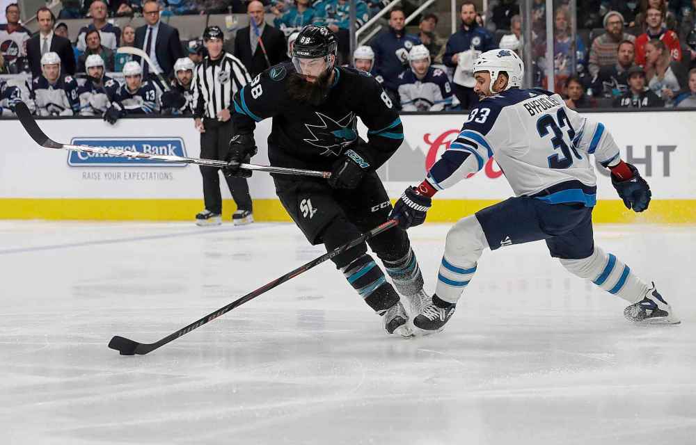 (AP Photo/Jeff Chiu)
Winnipeg Jets defenceman Dustin Byfuglien poke checks the puck past San Jose Sharks defenceman Brent Burns during the first period in San Jose, Calif., Thursday.