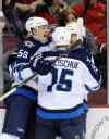 Bill Kostroun / The Associated Press
Winnipeg's Mark Scheifele (55) celebrates his first goal in weeks with linemates Matt Halischuk and Michael Frolik.