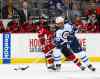 Rich Schultz / The Associated Press 
Winnipeg Jets defensemen Dustin Byfuglien (33) moves the puck away from New Jersey Devils center Adam Henrique (14) during the first period of an NHL hockey game in Newark, N.J., Friday night.