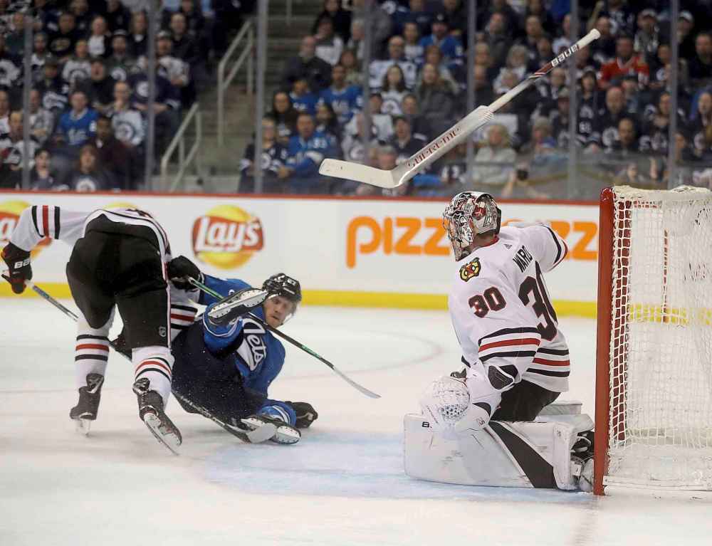 THE CANADIAN PRESS/Trevor Hagan
Chicago Blackhawks' Jan Rutta trips up Nikolaj Ehlers in front of goaltender Cam Ward (30) whose stick goes flying after trying to knock the puck away during the second period Tuesday.