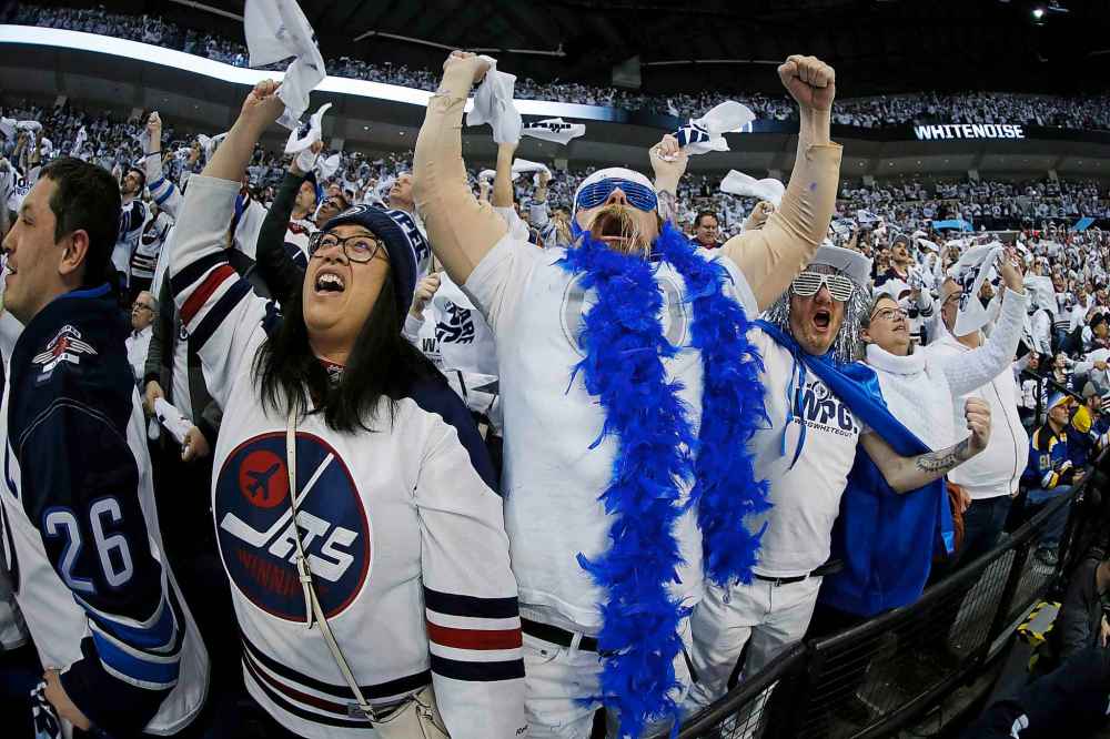 THE CANADIAN PRESS/John Woods
Jets fans celebrate right winger Patrik Laine's goal during the first period.