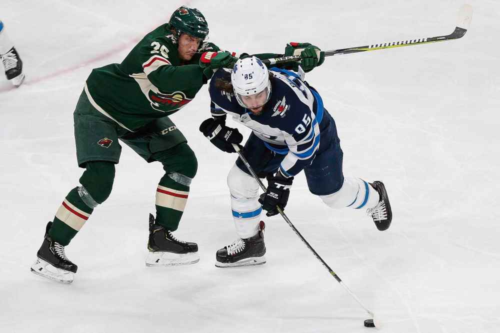 (AP Photo/Stacy Bengs)
Winnipeg Jets' Mathieu Perreault tries to control the puck in front of Minnesota Wild's Jonas Brodin in the third period Thursday.