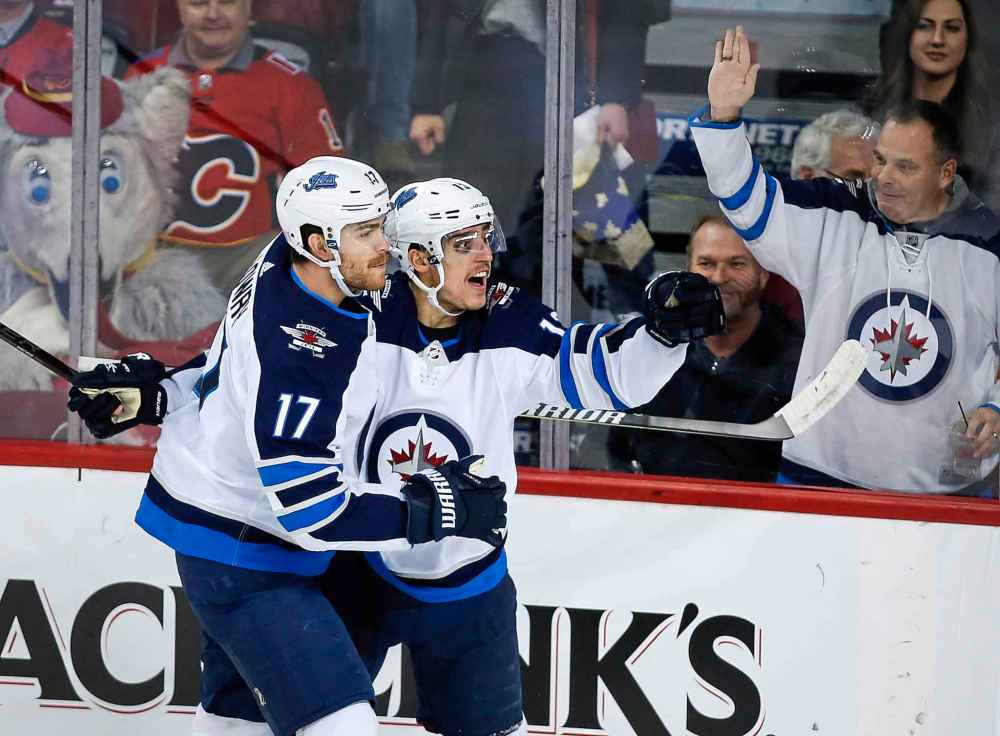 THE CANADIAN PRESS/Jeff McIntosh
Winnipeg Jets' Brandon Tanev, right, celebrates his goal just 15 seconds into the first period with teammate Adam Lowry in Calgary, Wednesday.