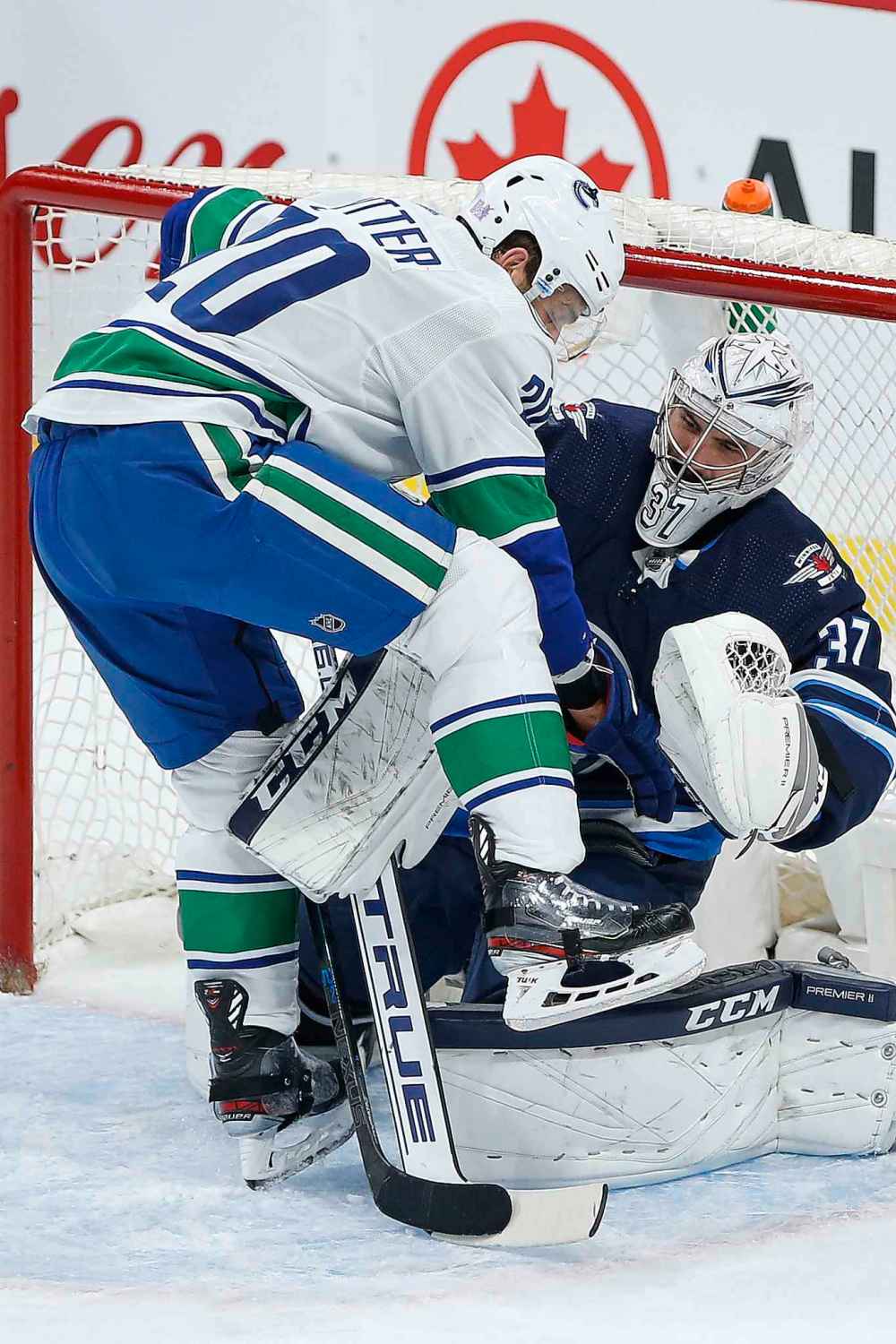 THE CANADIAN PRESS/John Woods
Winnipeg Jets goaltender Connor Hellebuyck (37) and Vancouver Canucks' Brandon Sutter (20) get tangled up during first period NHL action in Winnipeg, Friday, Nov. 8, 2019.