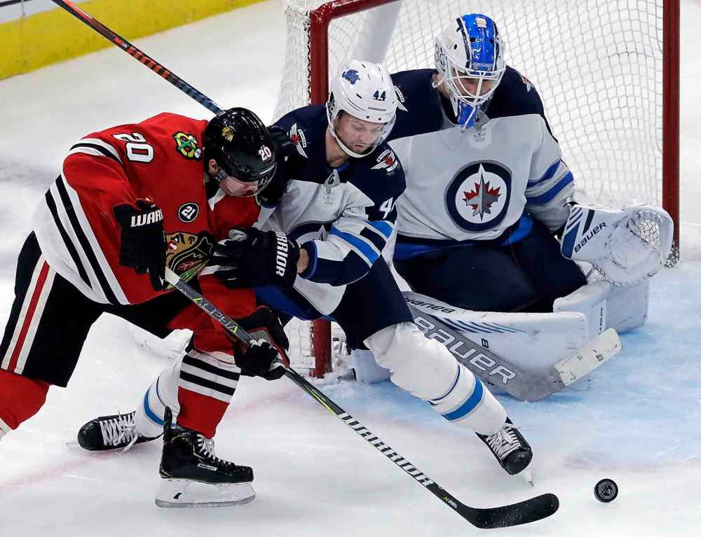 (AP Photo/Nam Y. Huh)
Chicago Blackhawks' Brandon Saad, left, battles against Winnipeg Jets defenceman Josh Morrissey, while goalie Laurent Brossoit keeps his eyes on the puck during the third period.