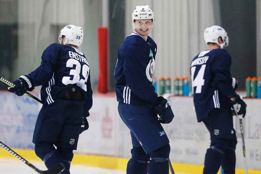 CP
Winnipeg Jets' Jacob Trouba, (8) of the United States, jokes with Toby Enstrom, (39) of Sweden, during speed trials on the second day of the Jets' training camp in Winnipeg on Friday, September 15, 2017. THE CANADIAN PRESS/John Woods