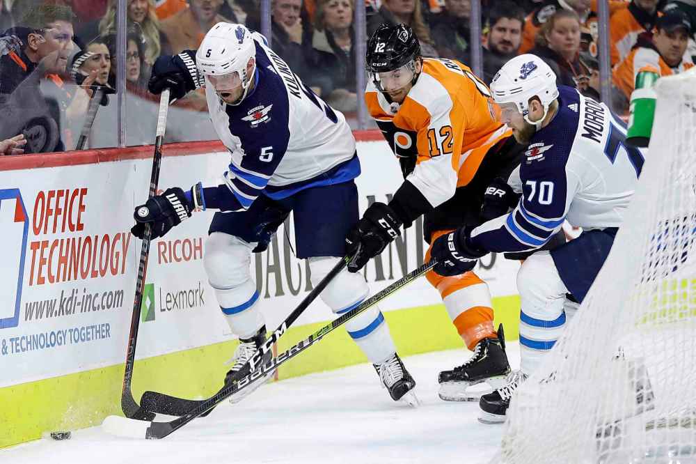 (AP Photo/Matt Slocum)
Philadelphia Flyers' Michael Raffl battles for the puck between Winnipeg Jets' Dmitry Kulikov (left) and Joe Morrow during the second period.