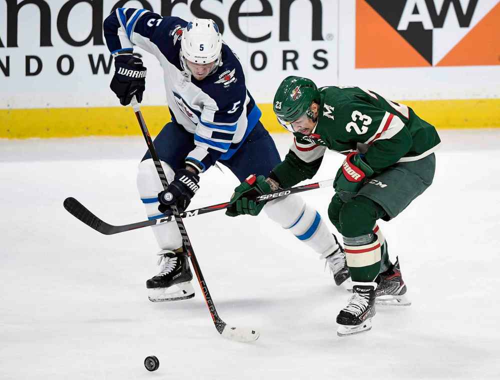(AP Photo/Hannah Foslien)
Winnipeg Jets defenceman Dmitry Kulikov battles with Minnesota Wild right wing J.T. Brown during the first period.