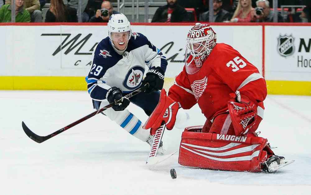 (AP Photo/Duane Burleson)
Detroit Red Wings goaltender Jimmy Howard deflects a shot as Winnipeg Jets right wing Patrik Laine looks for a rebound during the first period Friday in Detroit.