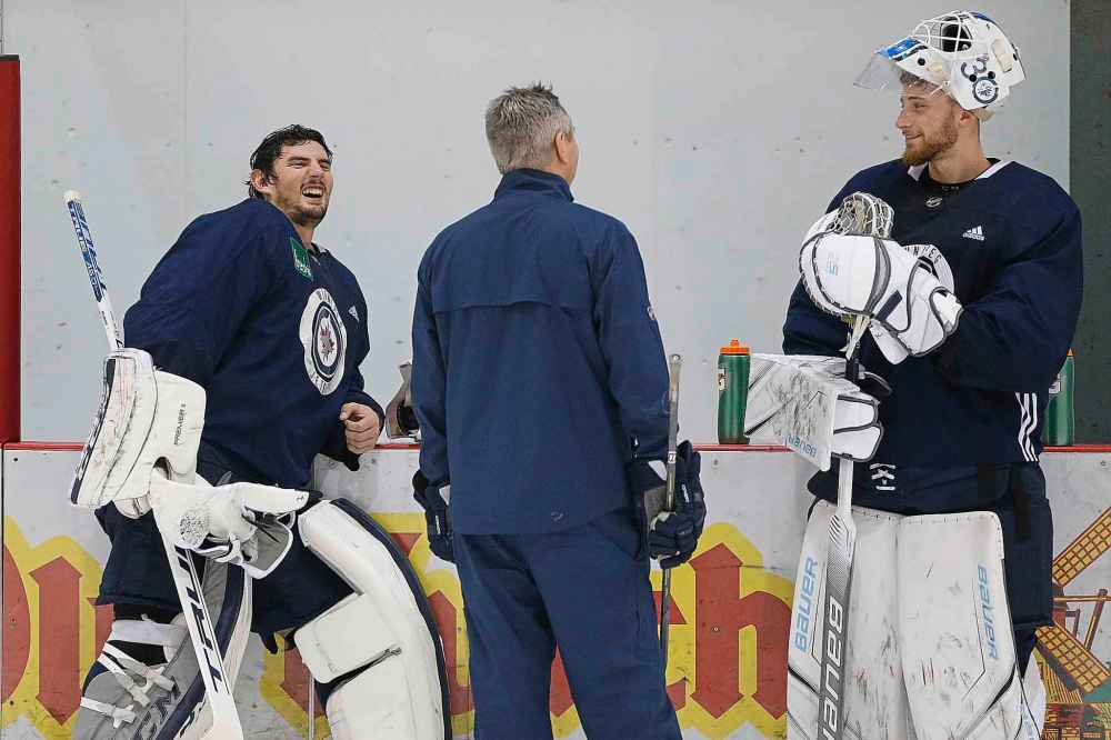 JOHN WOODS / WINNIPEG FREE PRESS FILES
Winnipeg Jets goaltenders Connor Hellebuyck, left, and Laurent Brossoit chat with a coach at practice in October.