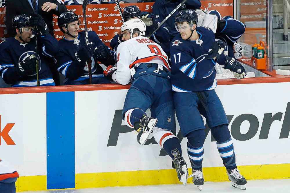 THE CANADIAN PRESS/John Woods
Winnipeg Jets' Adam Lowry checks Washington Capitals' Alex Ovechkin during the first period.
