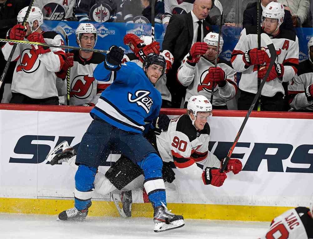 THE CANADIAN PRESS/Fred Greenslade
Winnipeg Jets' Adam Lowry checks New Jersey Devils' Jesper Boqvist during the first period.