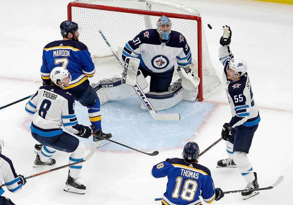 (AP Photo/Jeff Roberson)
Winnipeg Jets centre Mark Scheifele reaches for the puck in front of goaltender Connor Hellebuyck during the first period.