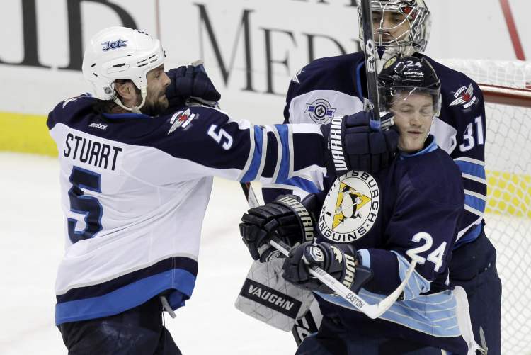Gene J. Puskar/ The Associated Press archives
Jets defenceman Mark Stuart lets out a little frustration against Penguins forward Matt Cooke as goalie Ondrej Pavalec looks on during Saturday’s messy loss.