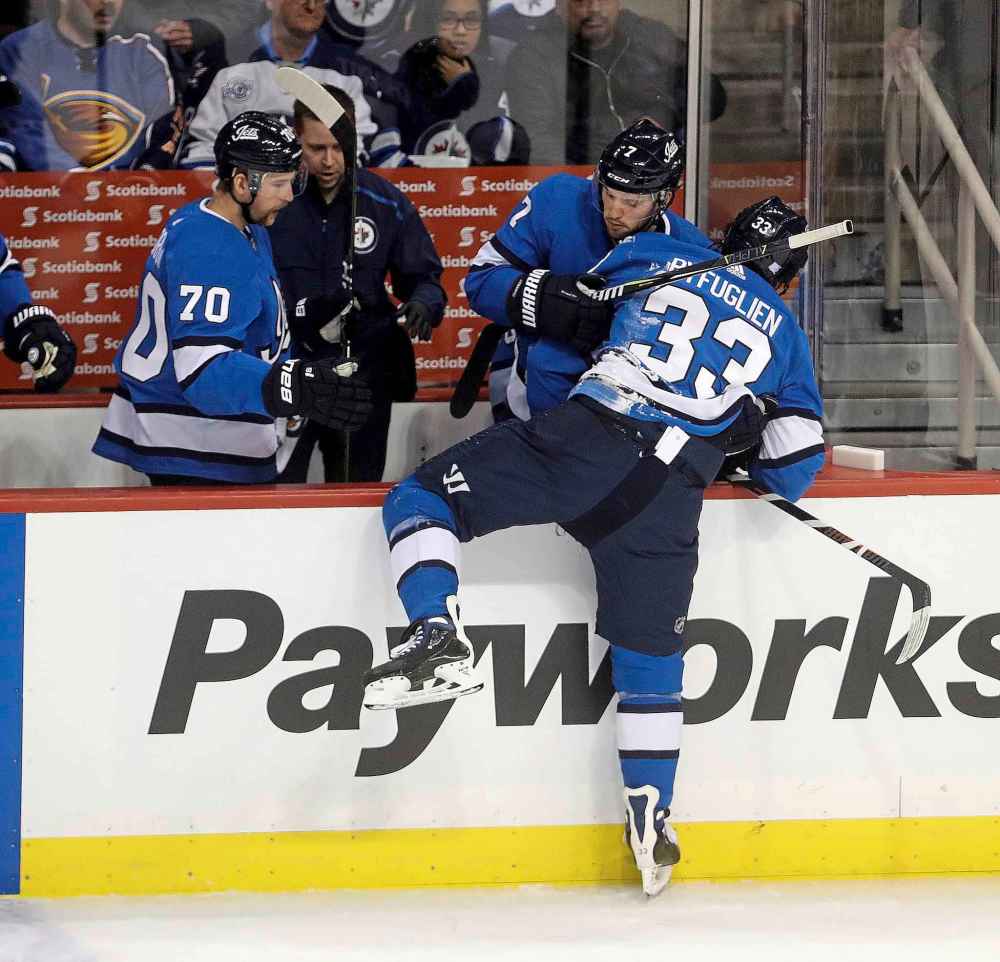 THE CANADIAN PRESS/Trevor Hagan
Winnipeg Jets' Ben Chiarot tries to help a clearly-shaken Dustin Byfuglien get off the ice after the collision with Penguins' Oleksiak.