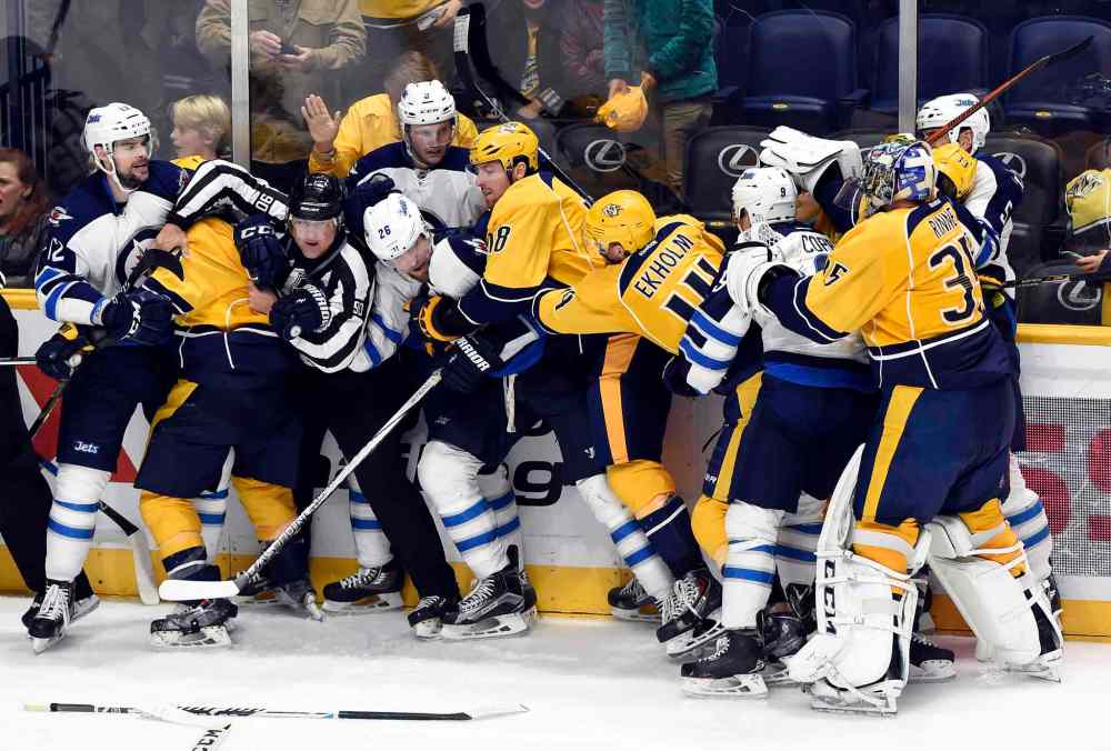 Mark Zaleski / The Associated Press files
Linesman Andy McElman (90) tries to break up a fight between the Nashville Predators and the Winnipeg Jets in the third period of an NHL hockey game, Saturday, Nov. 14, 2015, in Nashville, Tenn. The Predators won 7-0.