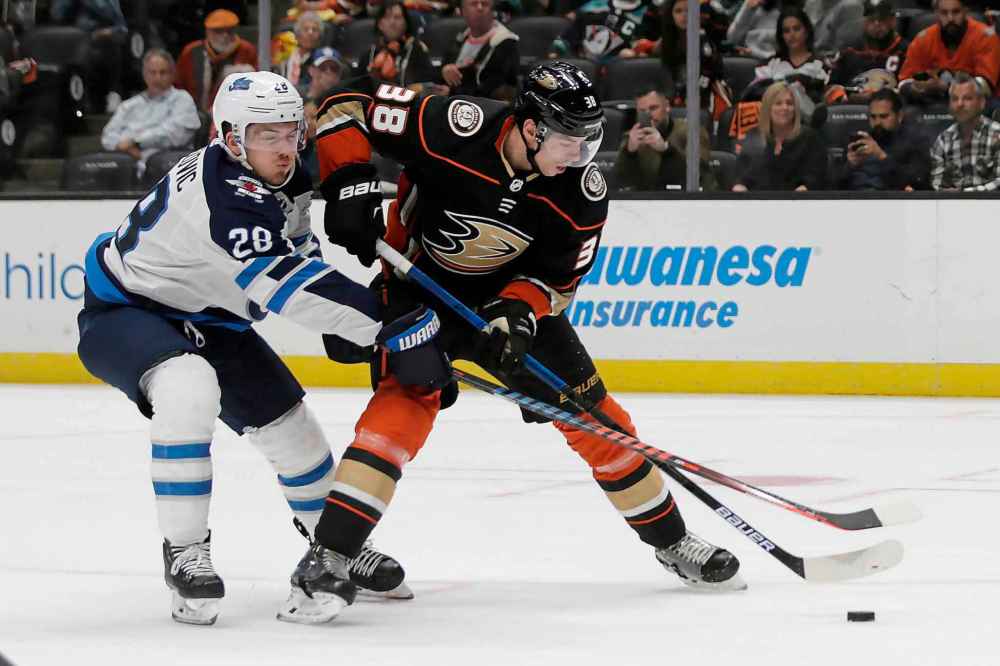 (AP Photo/Alex Gallardo)
Anaheim Ducks centre Derek Grant, right, controls the puck in front of Winnipeg Jets' Jack Roslovic during the second period.