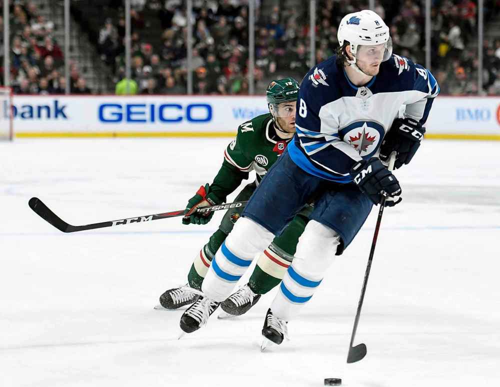 (AP Photo/Hannah Foslien)
Winnipeg Jets defenceman Jacob Trouba carries the puck while shorthanded against Minnesota Wild centre Luke Kunin during the second period Tuesday. Trouba would score on the play.