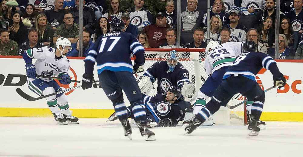 TREVOR HAGAN / WINNIPEG FREE PRESS
Winnipeg Jets' goaltender Connor Hellebuyck makes a stop as Josh Morrissey falls in front of the net during the second period against the Vancouver Canucks', Thursday.