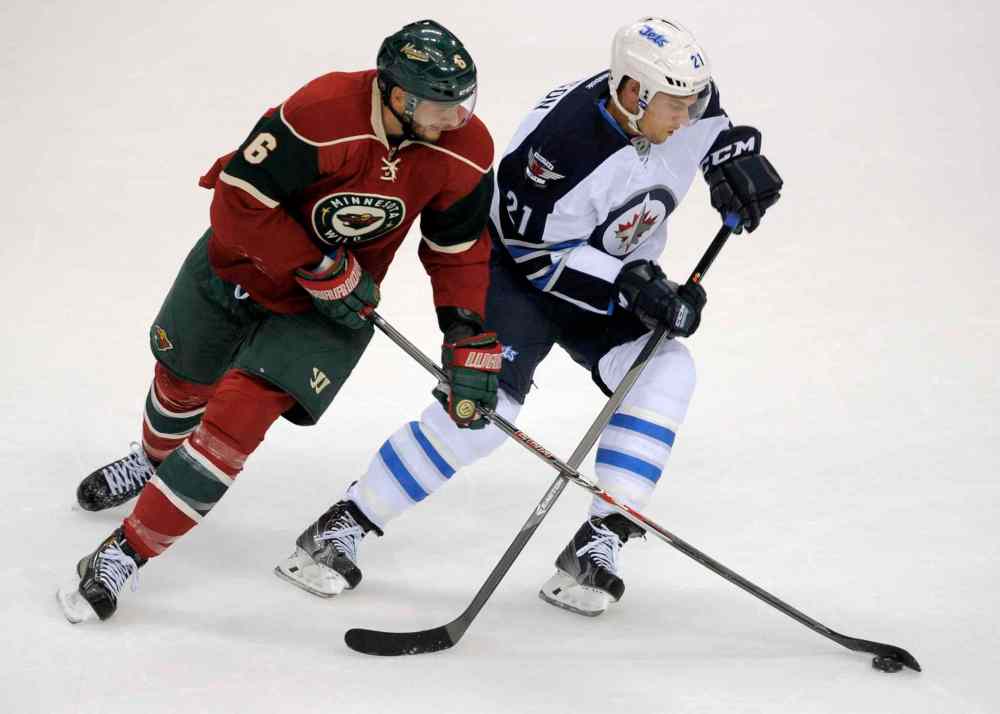 Tom Olmscheid / The Associated Press
Minnesota Wild's Marco Scandella, left, and Winnigeg Jets' Jerome Samson, right, go after the puck in the first period of an NHL hockey game on Saturday, Sept. 21, 2013, in St. Paul, Minn. (AP Photo/Tom Olmscheid)