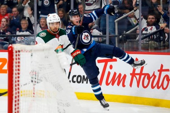 Winnipeg Jets' Patrik Laine (29) celebrates his go ahead goal as Minnesota Wild's Matt Dumba (24) skates by during second period NHL action in Winnipeg on Thursday, October 10, 2019. THE CANADIAN PRESS/John Woods