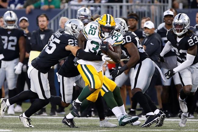 Green Bay Packers' Tra Carson (32) makes yards as Oakland Raiders' Erik Harris (25) attempts the tackle during the first half of NFL pre-season action in Winnipeg Thursday, August 22, 2019. THE CANADIAN PRESS/John Woods