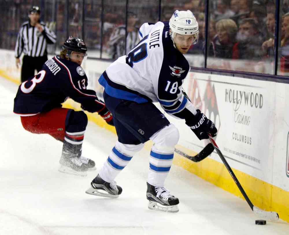 Paul Vernon / The Associated Press
Winnipeg Jets' Bryan Little, right, works for the puck against Columbus Blue Jackets' Cam Atkinson during the first period of an NHL hockey game in Columbus, Ohio, Saturday.