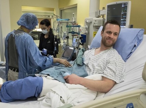 Josh McQuillin, right, of Prince George, B.C., who is the first Canadian in history to receive a direct intravenous injection gene replacement therapy, undergoes tests at the University of Calgary's clinical trials unit in Calgary, Alta., Thursday, March 14, 2019. THE CANADIAN PRESS/Jeff McIntosh