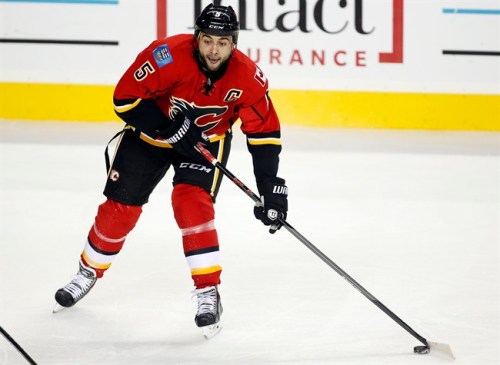 New Calgary Flames captain Mark Giordano passes the puck during first period NHL pre-season hockey action against the New York Rangers in Calgary, Monday, Sept. 23, 2013. The quick restoration of their home arena after massive flooding is a message for the rebuilding Calgary Flames.Less than three months after the Elbow River destroyed everything below the eighth row of seats in the Scotiabank Saddledome, the arena was not only operational again, but the affected areas are bright and polished for the 2013-14 NHL season. THE CANADIAN PRESS/Jeff McIntosh