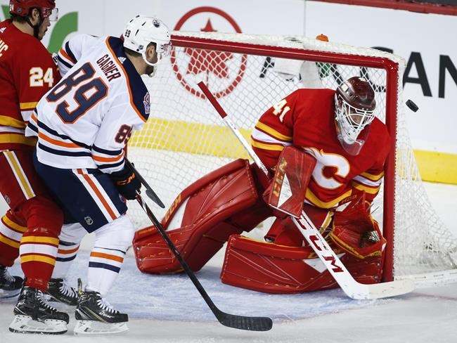 Edmonton Oilers' Sam Gagner, left, has his shot deflected by Calgary Flames goalie Mike Smith during first period NHL hockey action in Calgary, Saturday, April 6, 2019.THE CANADIAN PRESS/Jeff McIntosh