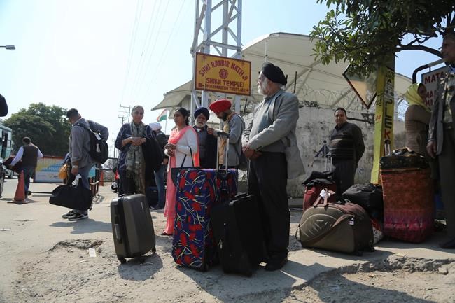 Stranded passengers stand outside an airport after it was closed for civilians operations amid tension along the border with Pakistan in Jammu, India, Wednesday, Feb. 27, 2019. Pakistan shot down two Indian warplanes Wednesday in the disputed region of Kashmir and captured their pilots, its military said, raising tensions between the nuclear-armed rivals to a level unseen in 20 years. (AP Photo/Channi Anand)