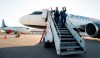 Conservative leader Andrew Scheer and his wife Jill get off their campaign plane as they arrive in Toronto, Tuesday, October 8, 2019. NDP leader Jagmeet Singh's campaign plane is pictured in the background. THE CANADIAN PRESS/Jonathan Hayward