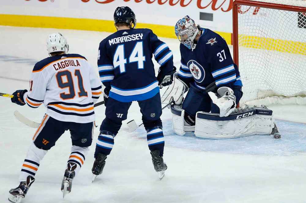 THE CANADIAN PRESS/John Woods
Edmonton Oilers' Ryan Spooner's shot sneaks past Winnipeg Jets goaltender Connor Hellebuyck as Josh Morrissey and Oilers' Drake Caggiula look on during the first period.