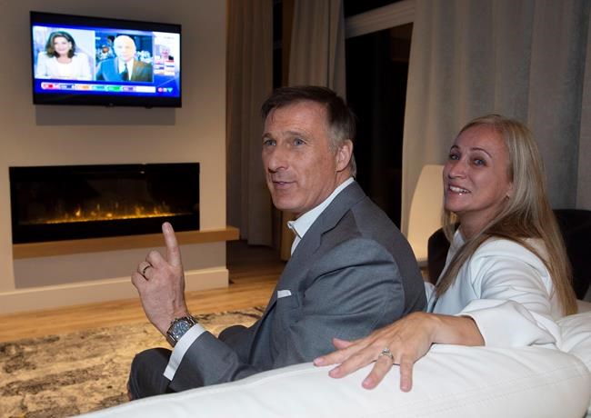 People's Party of Canada Leader Maxime Bernier and his wife Catherine Letarte watches elections results on television Monday, October 21, 2019 in Beauceville, Que. Canadians are going to the polls in a general election. THE CANADIAN PRESS/Jacques Boissinot