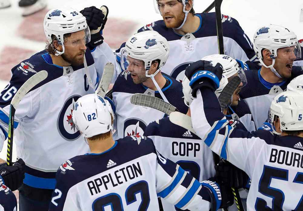 Blake Wheeler is congratulated by teammates after scoring in the shootout against the New Jersey Devils Friday Night in Newark. (Noah K. Murray / The Associated Press)