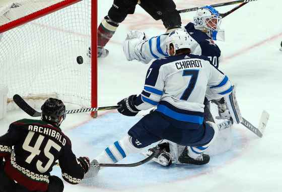 ROSS D. FRANKLIN / THE ASSOCIATED PRESSA shot by Arizona Coyotes' Lawson Crouse goes off of Winnipeg Jets defenseman Ben Chiarot (7) and past Jets goaltender Laurent Brossoit, right, for a goal as Coyotes right wing Josh Archibald (45) looks on during the second period of an NHL hockey game Sunday, Feb. 24, 2019, in Glendale, Ariz.