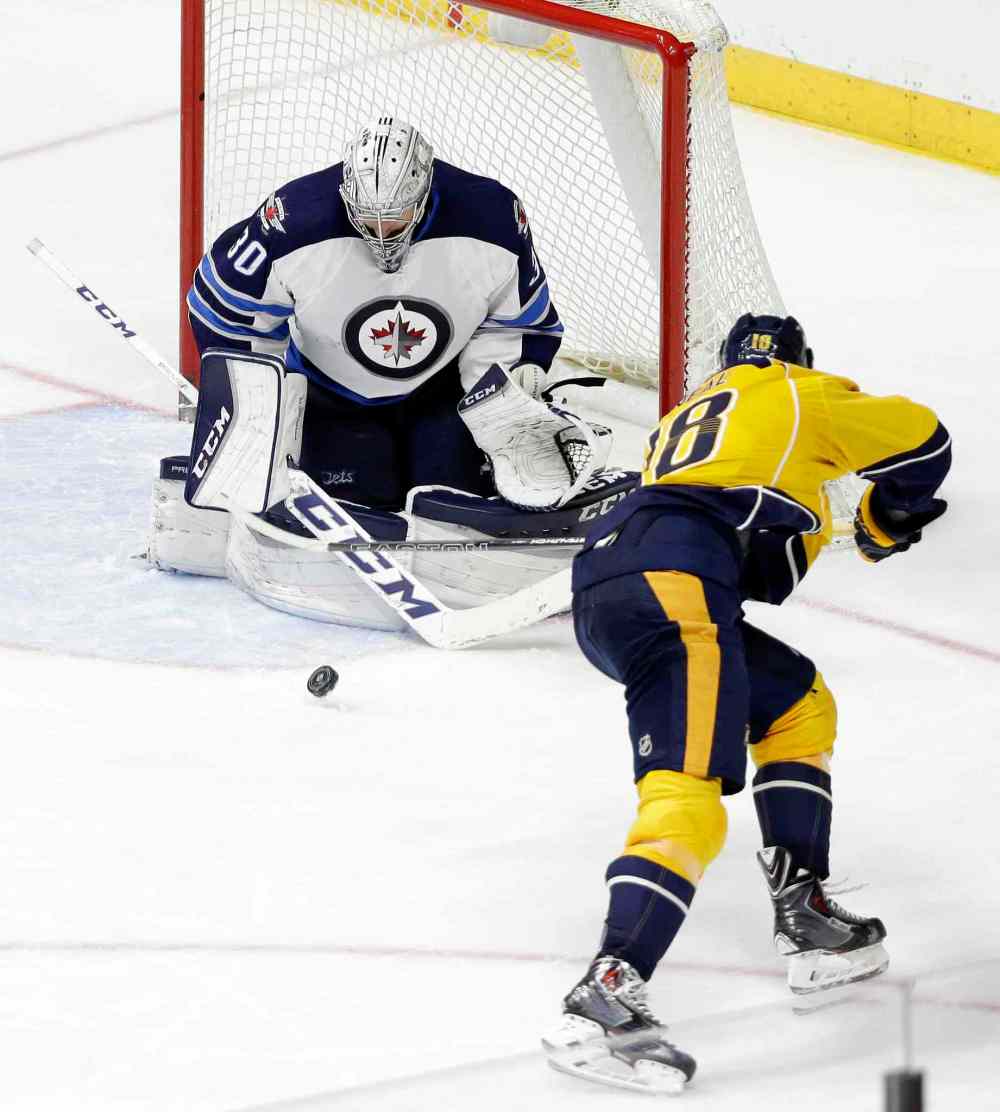 AP Photo/Mark Humphrey
Winnipeg Jets goalie Connor Hellebuyck (30) blocks a shot by Nashville Predators left wing James Neal (18) in the third period of an NHL hockey game Tuesday, Jan. 5, 2016, in Nashville, Tenn. The Jets won 4-1.